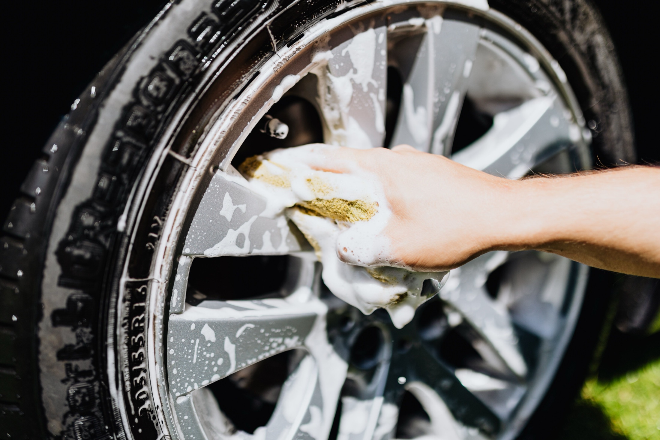 A car wheel and tire covered in cleaning foam